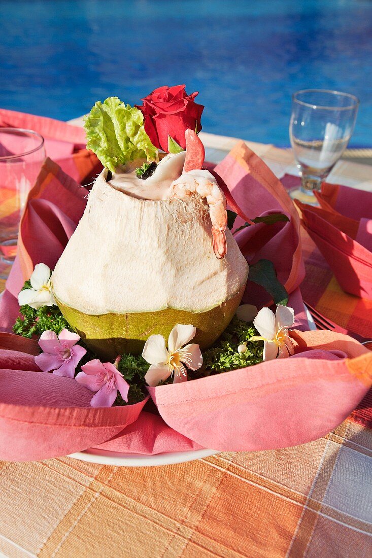 Shrimp cocktail with coconut milk served in a hollowed out coconut