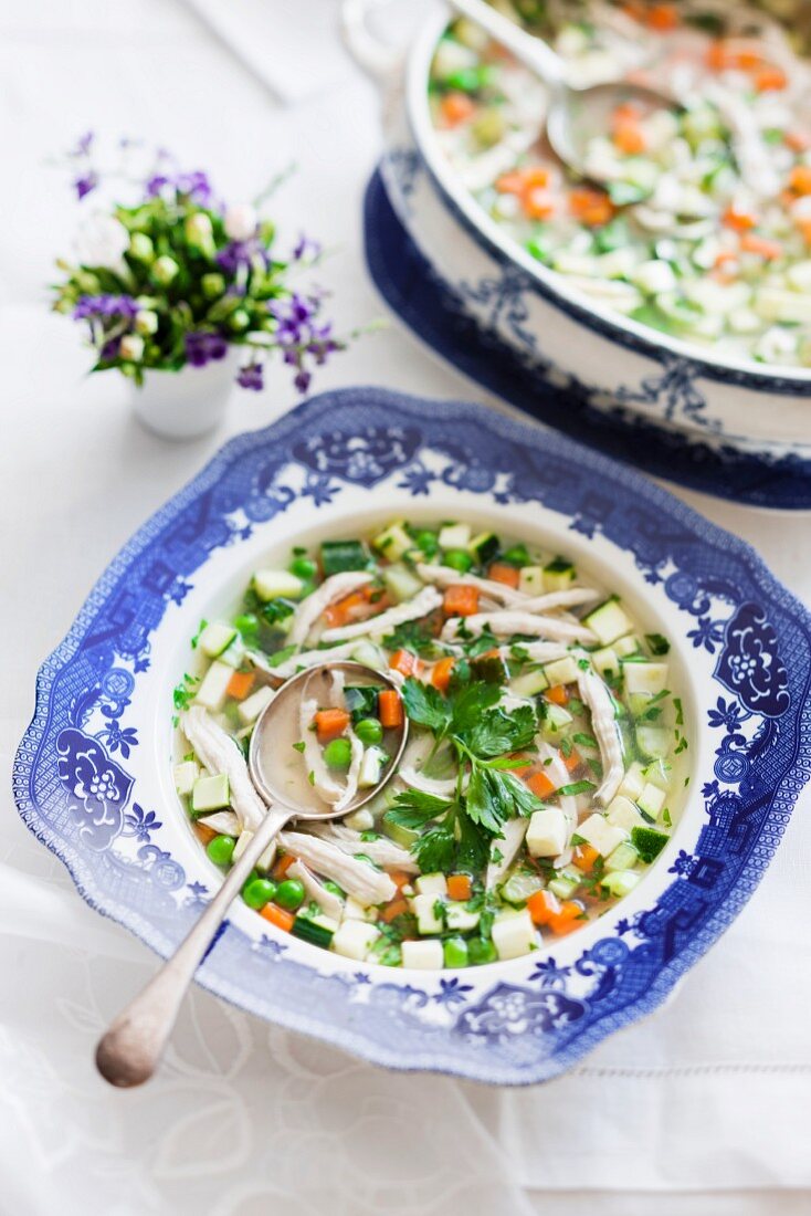 Clear chicken soup garnished with vegetables and meat