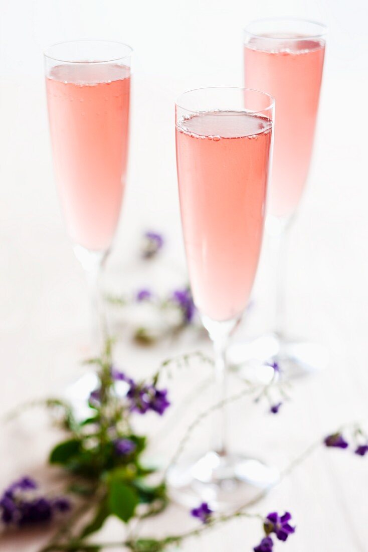 Drei rosafarbene Champagnercocktails
