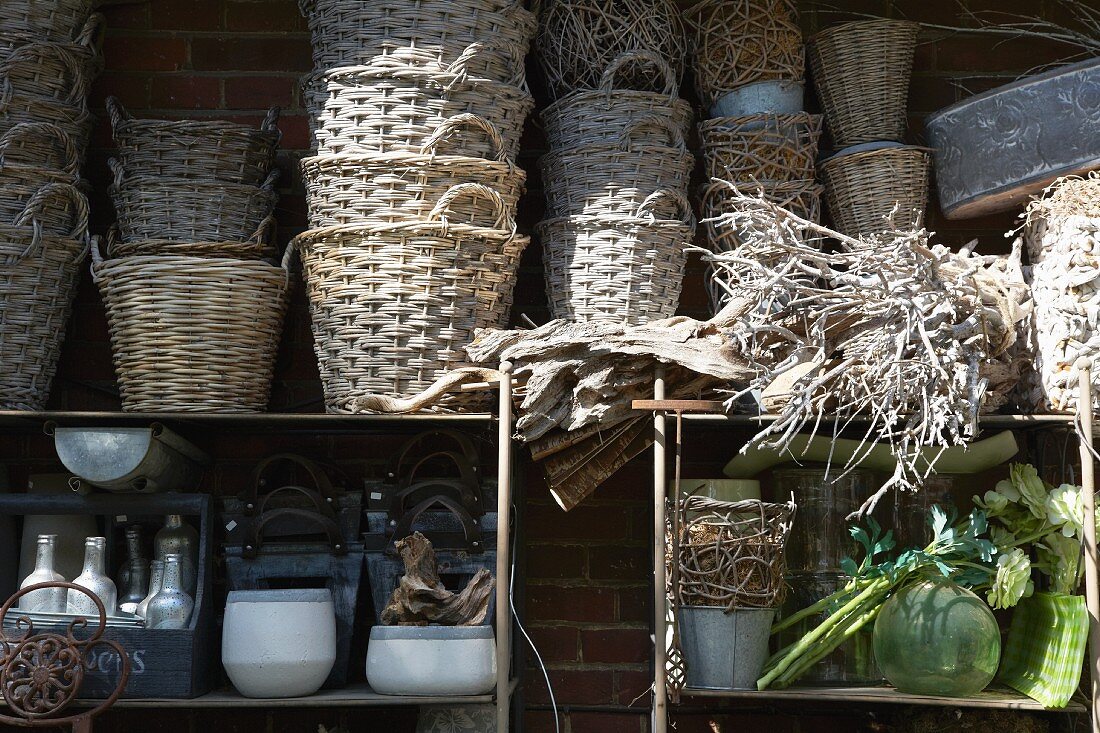 Wicker baskets and containers on a shelf with woven roots at the side