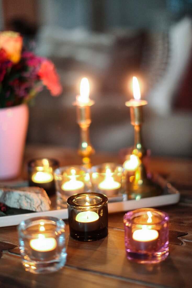Romantische Kerzenlichtstimmung mit mehreren Teelichtern auf rustikalem Holztisch