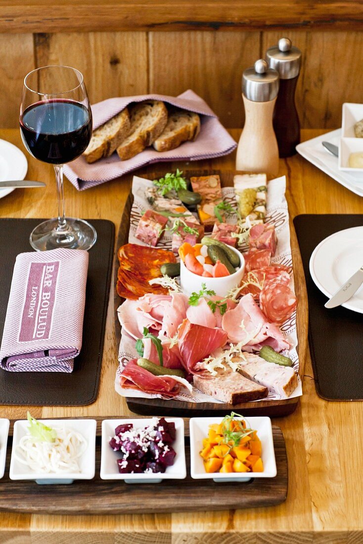 An appetiser platter with cold cuts and pickles in a restaurant