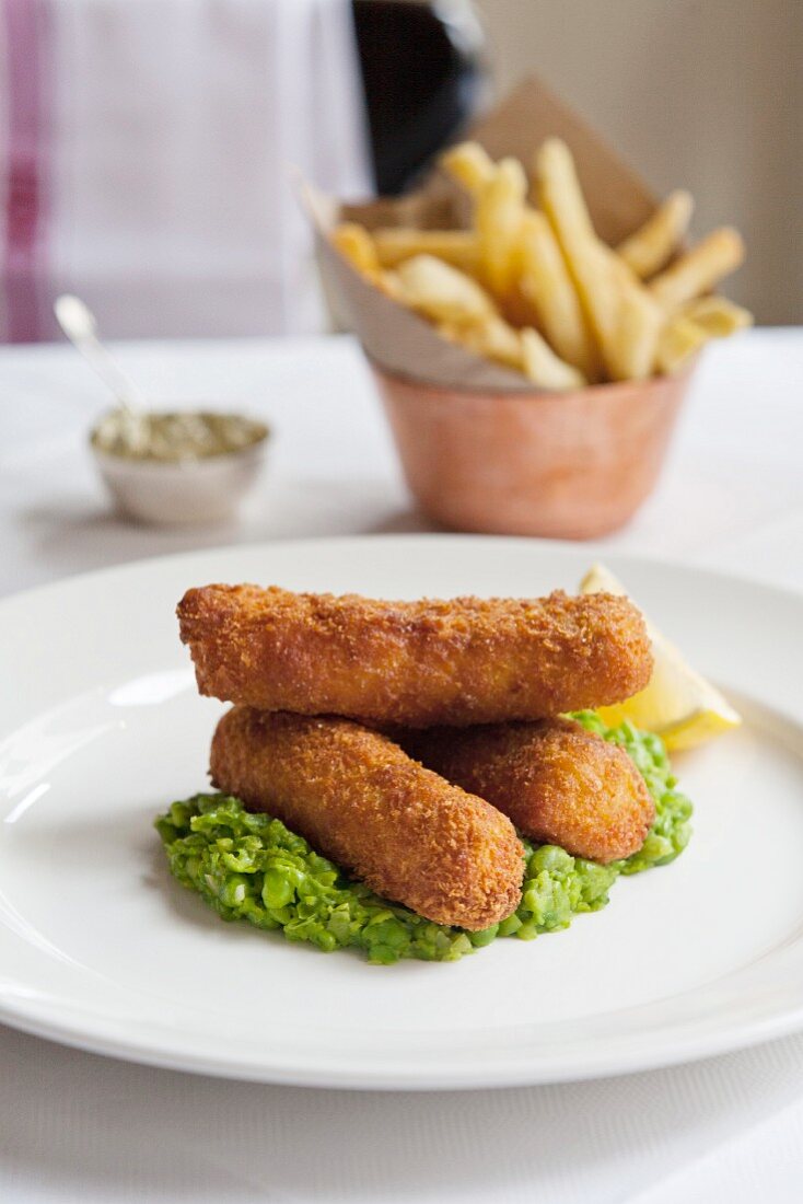 Fischstäbchen, Erbsenpüree und Pommes Frites im Restaurant