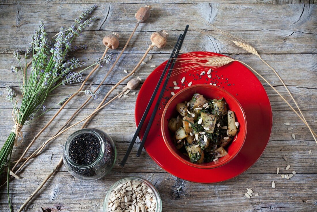 Fried Japanese turnips with leaves and seeds in a red bowl