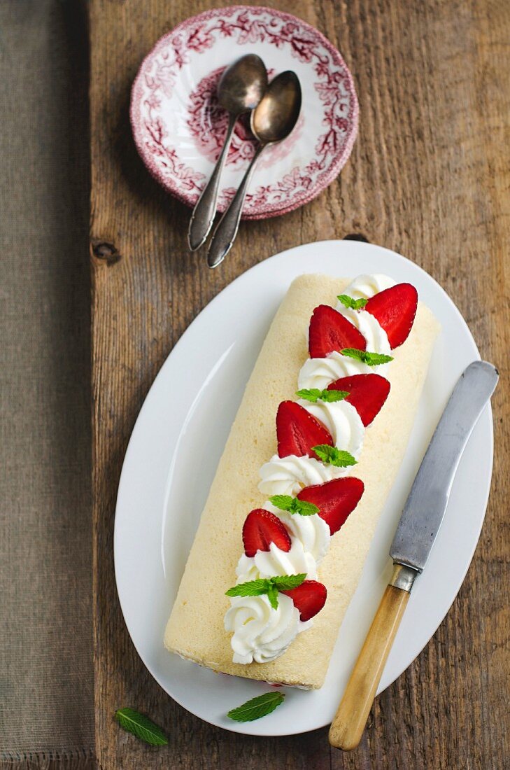 Swiss roll topped with strawberries and cream