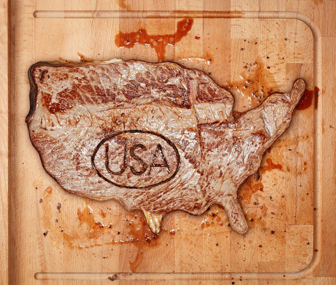 A beef steak with a USA stamp on a chopping board