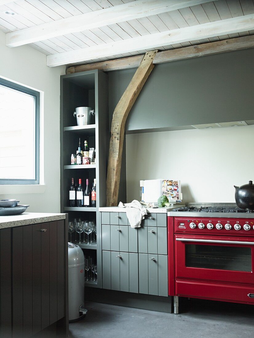 Kitchen with red, retro gas cooker and grey-painted cabinets in rustic interior