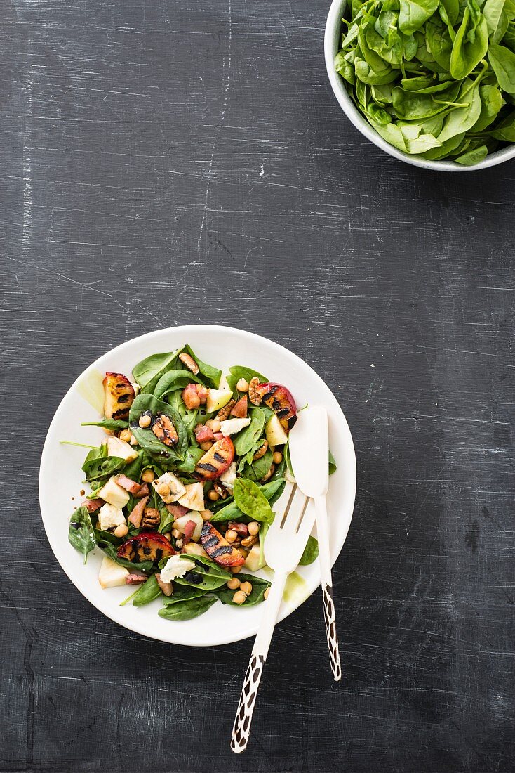 Spinach salad with chickpeas, gorgonzola, pecan nuts and grilled plums
