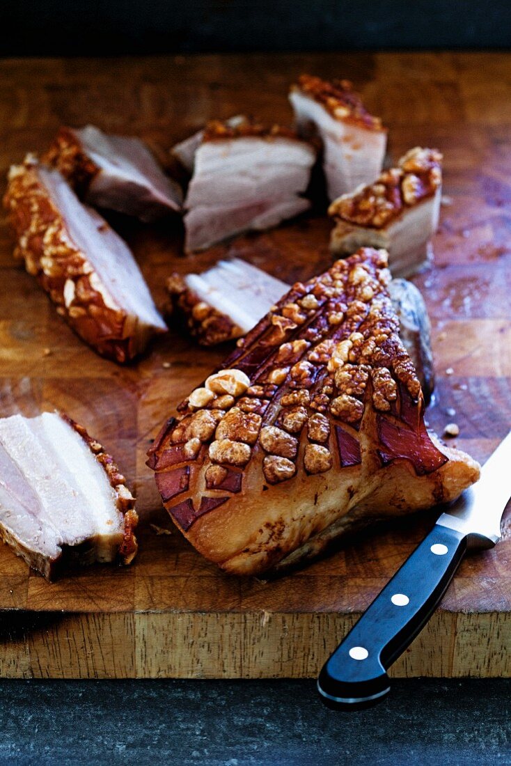 Roast belly pork with crackling on chopping board