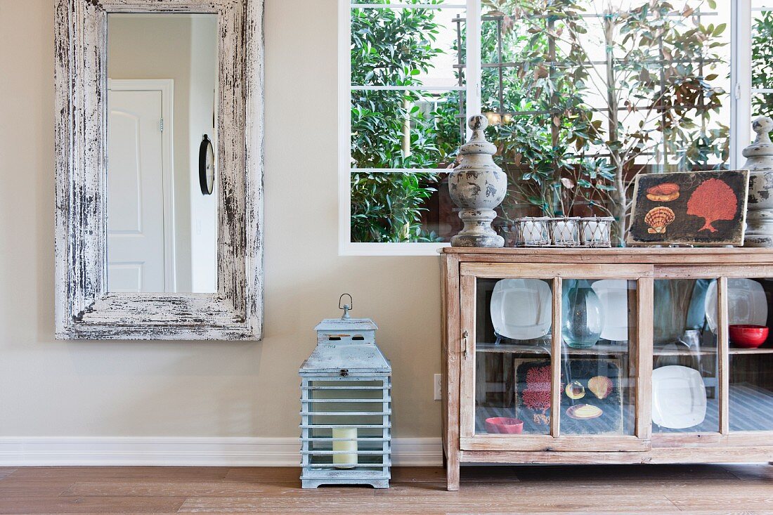 Rechteckiger Wandspiegel & Sideboard mit Glastüren vor Fenster in Wohnraum