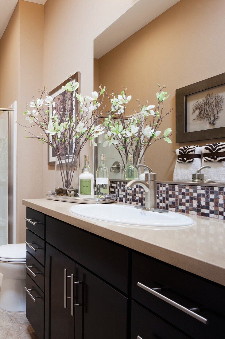 Bathroom sink with mirror and decorative flowers; Rancho Mission Viejo; California; USA