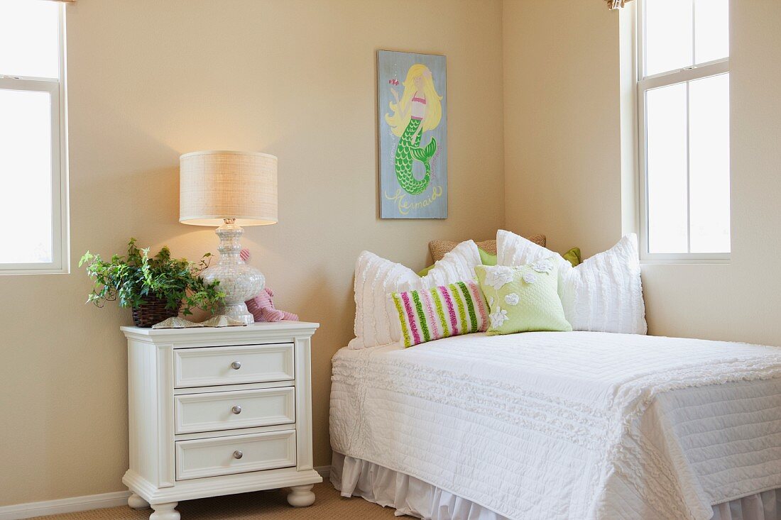 Bed with lit table lamp in a child's bedroom