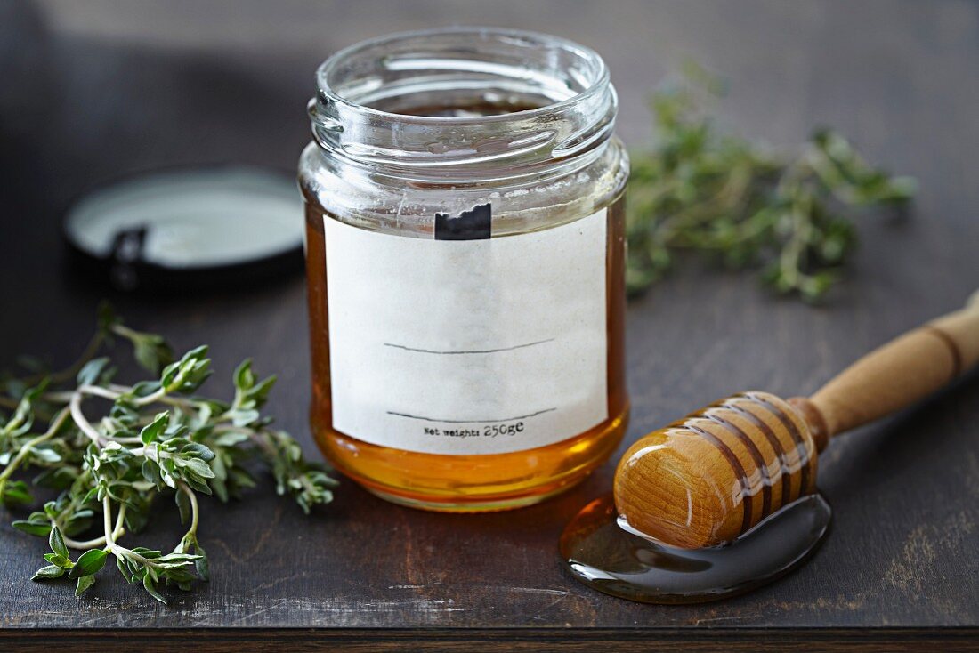 A jar of honey with a honey spoon