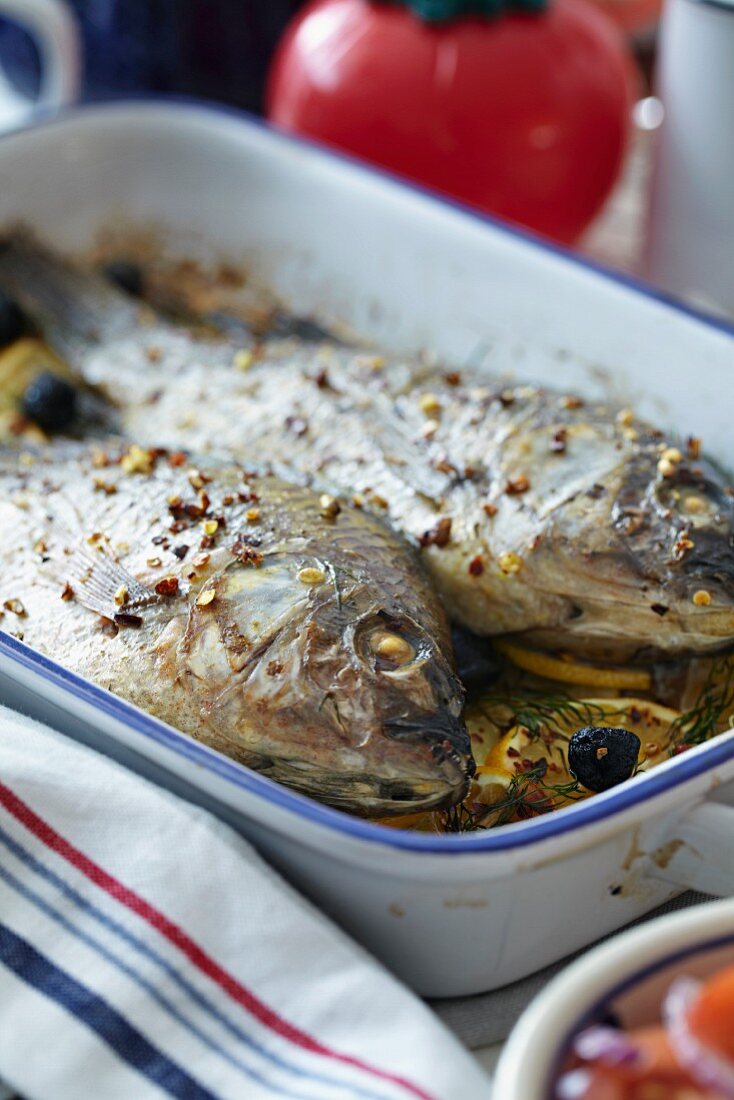 Bratreine mit zwei gebratenen Fischen auf Zitronenscheiben