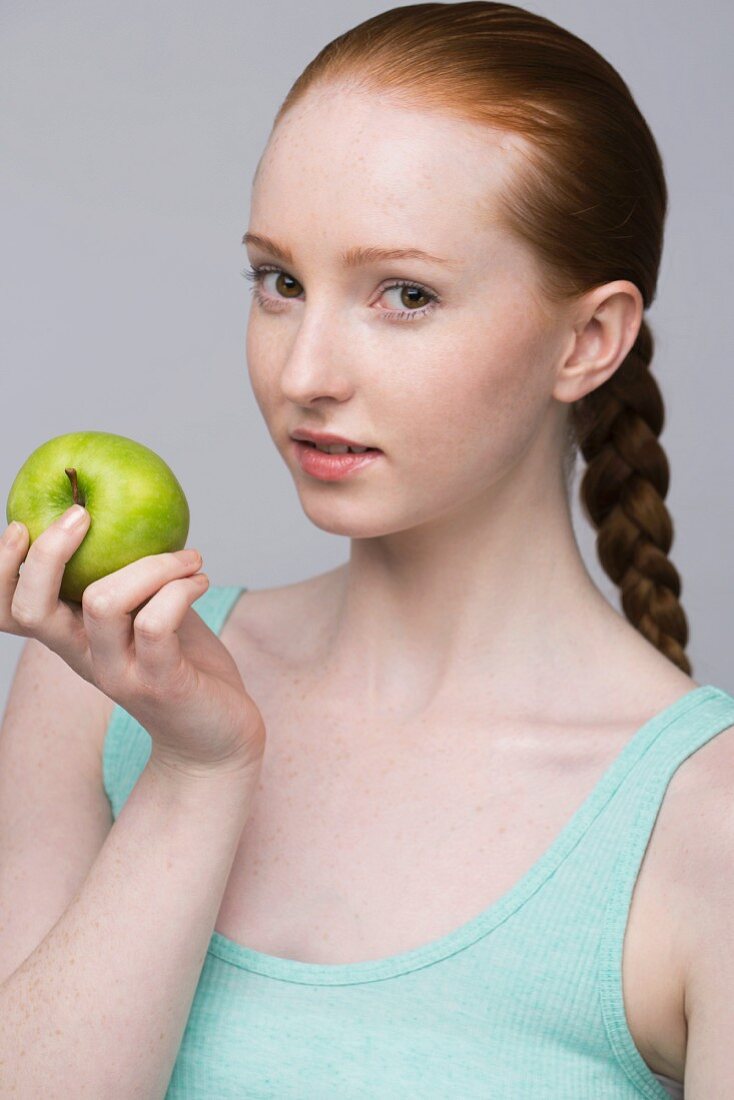Porträt einer jungen Frau mit grünem Apfel
