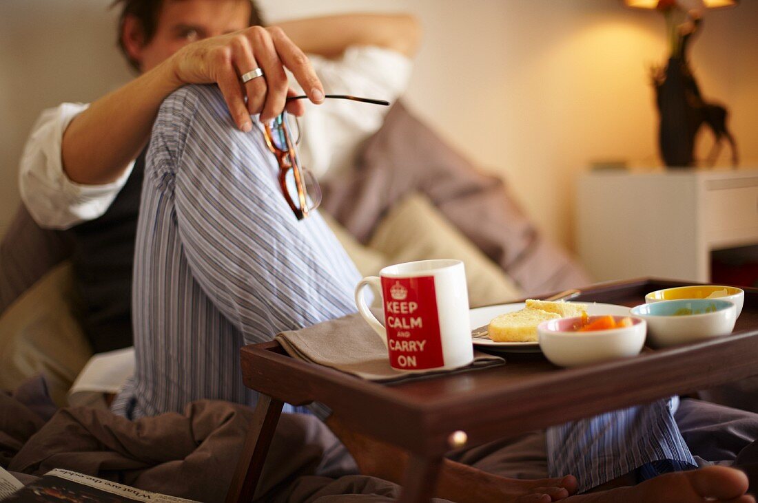 A man eating an English breakfast in bed