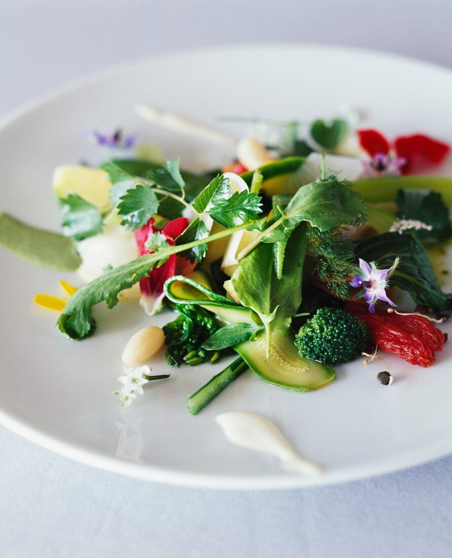 Green vegetable salad with dried tomatoes and borage flowers