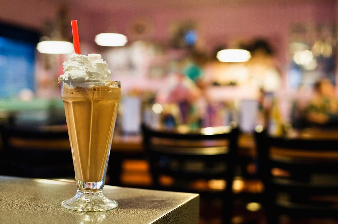 A chocolate milkshake topped with whipped cream