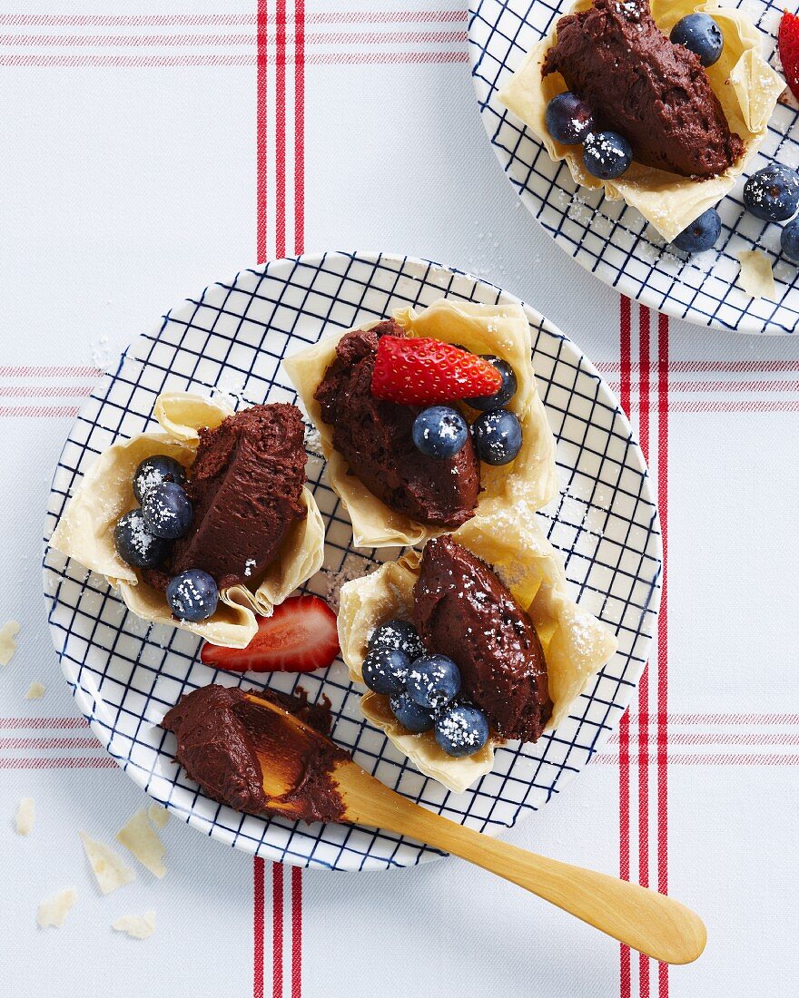 Teigschälchen gefüllt mit dunkler Schokoladenmousse mit frischen Erdbeeren und Heidelbeeren