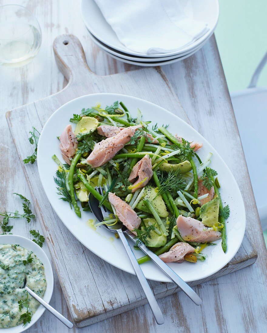 A salad made with green asparagus, avocado and smoked trout with dill