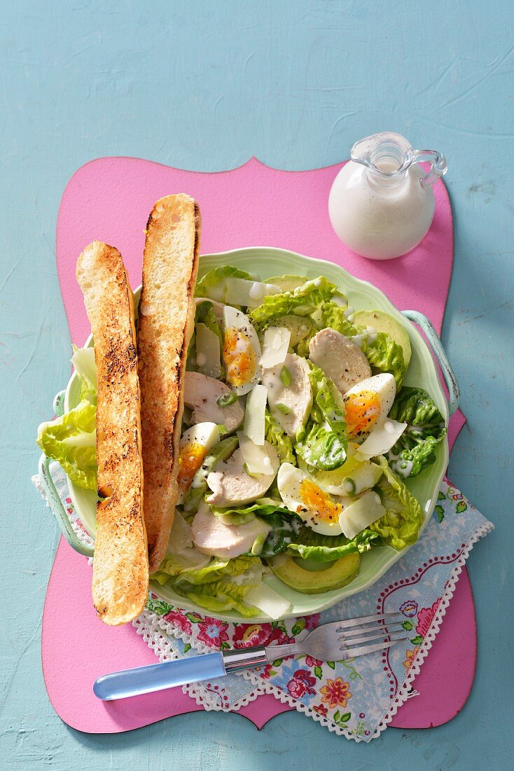 A Chicken Caesar salad served with crostini