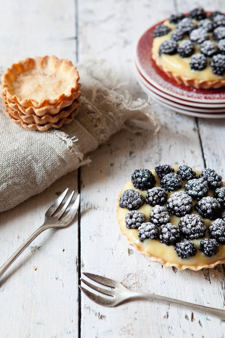 Blackberry tartlets with confectioner's cream and icing sugar