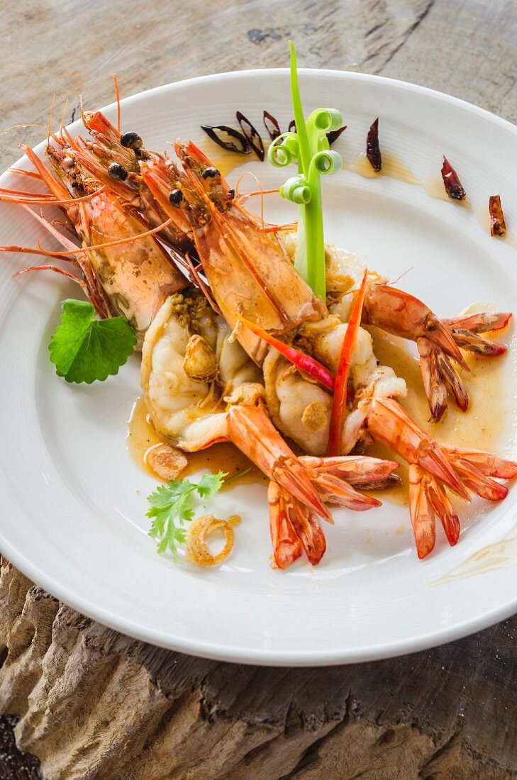 Whole king prawns with chilli peppers on a plate