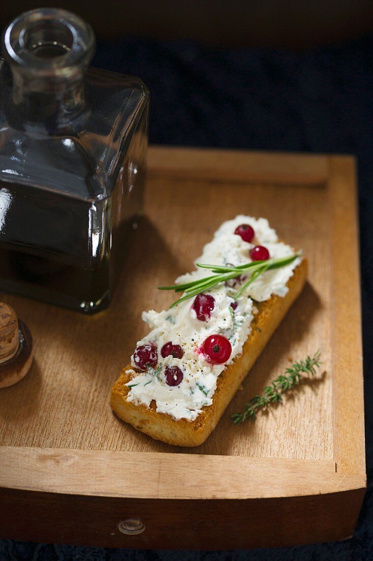 Bruschetta topped with rosemary and thyme cream cheese and redcurrants