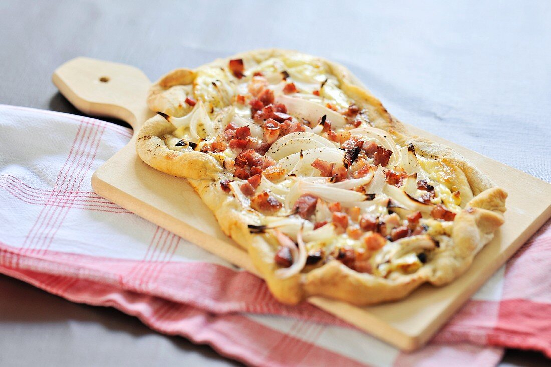 Tarte flambée topped with bacon and onions