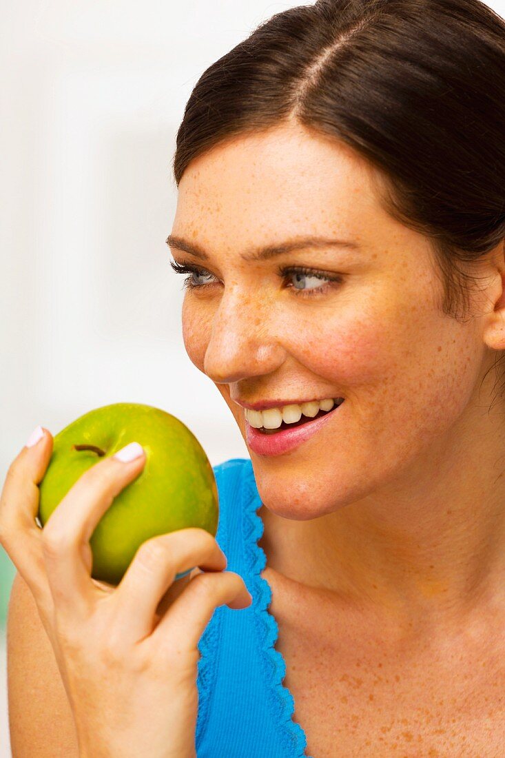 Junge brünette Frau mit grünem Apfel