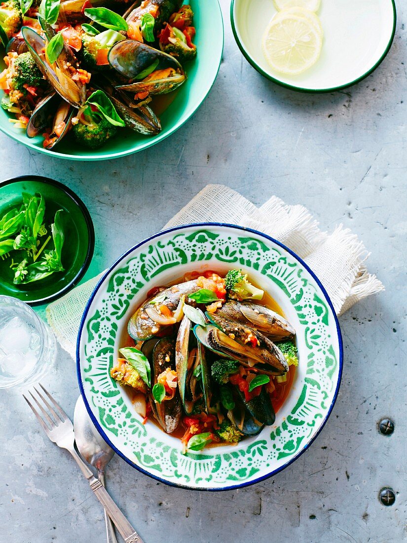 Mussels with broccoli in tomato sauce in a bowl and on a plate