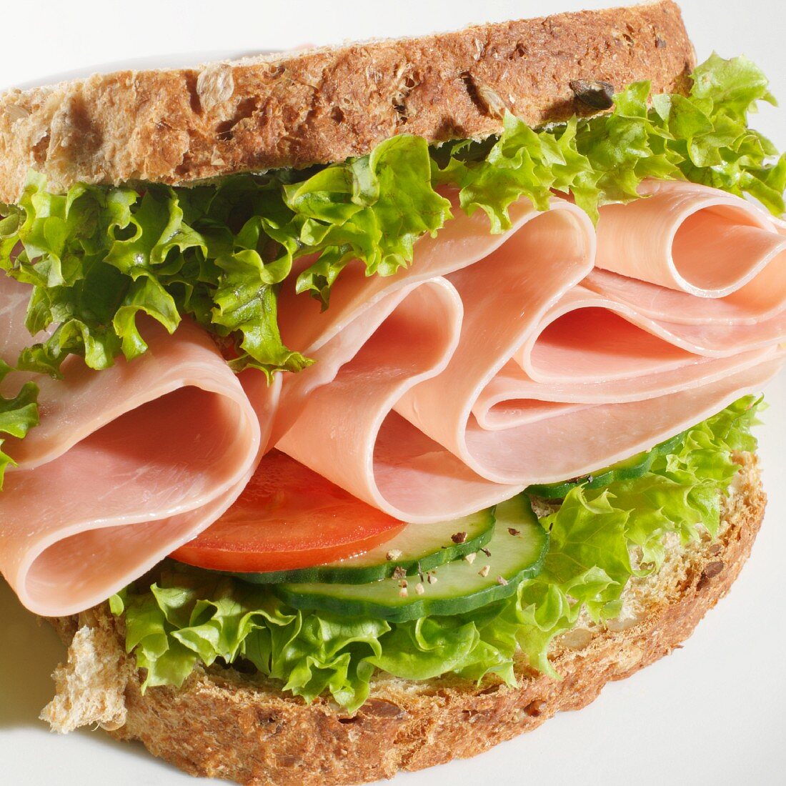 A ham sandwich with cucumber, tomato and lettuce