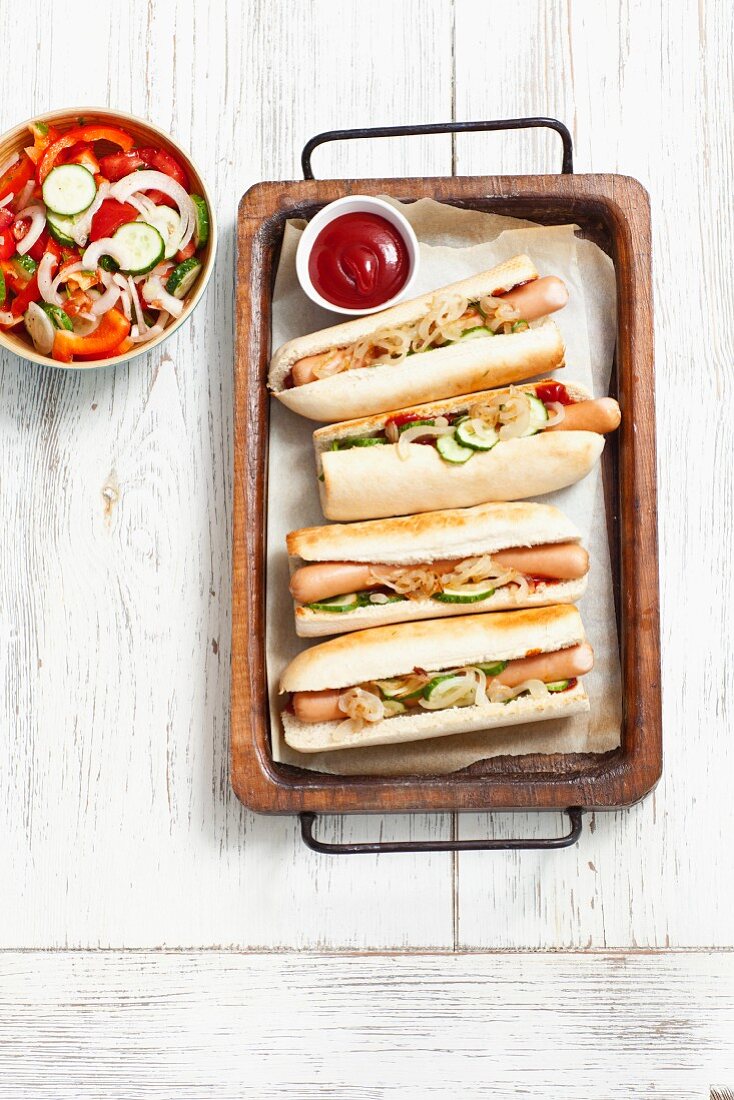 Hot Dogs mit Essiggurken, Ketchup und Zwiebelrelish