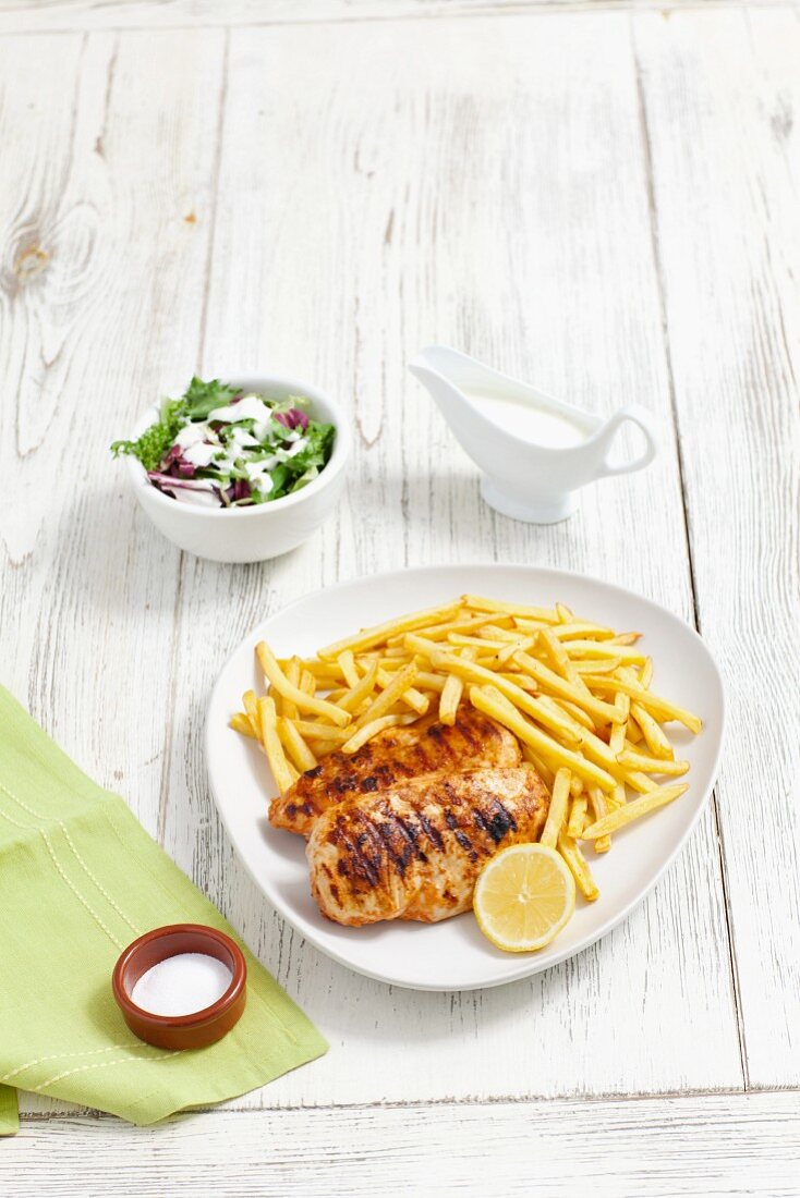 Gegrillte Hähnchenbrust mit Pommes frites und Salat