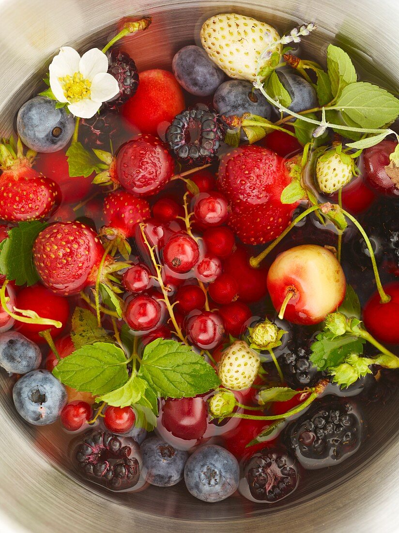 Fresh berries and cherries in a bowl of water