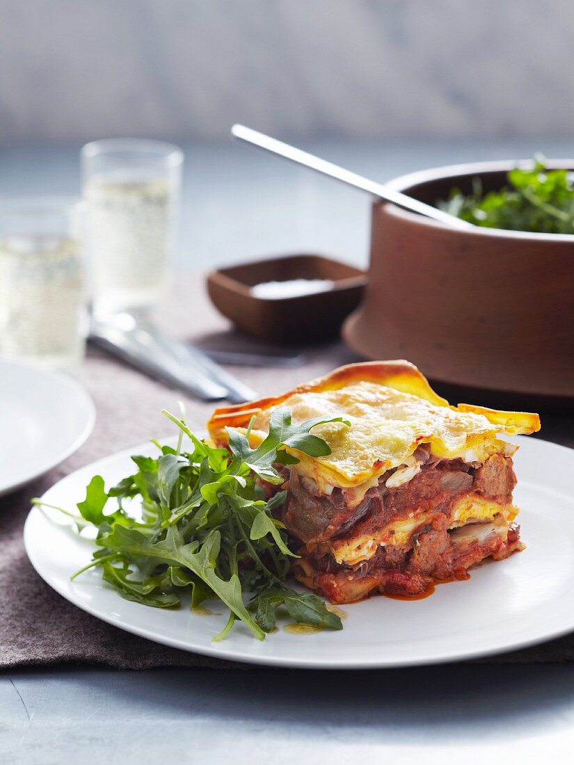 A portion of veal and pork lasagne with a rocket salad