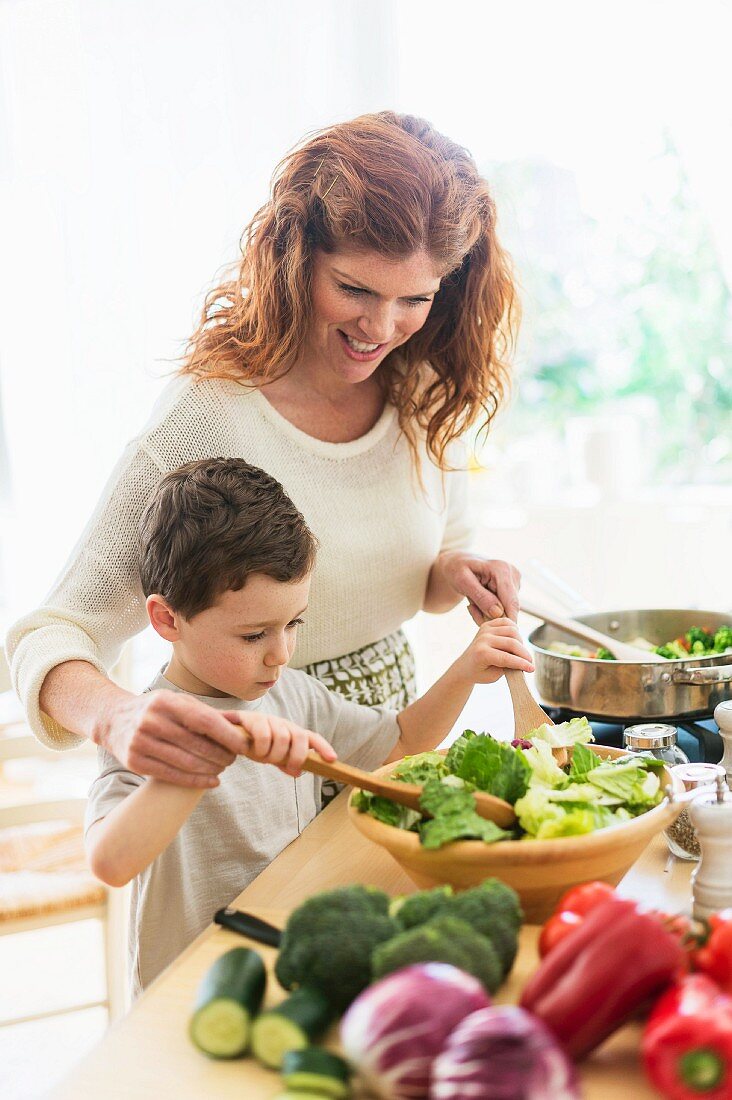 Mutter und Sohn kochen zusammen Salat