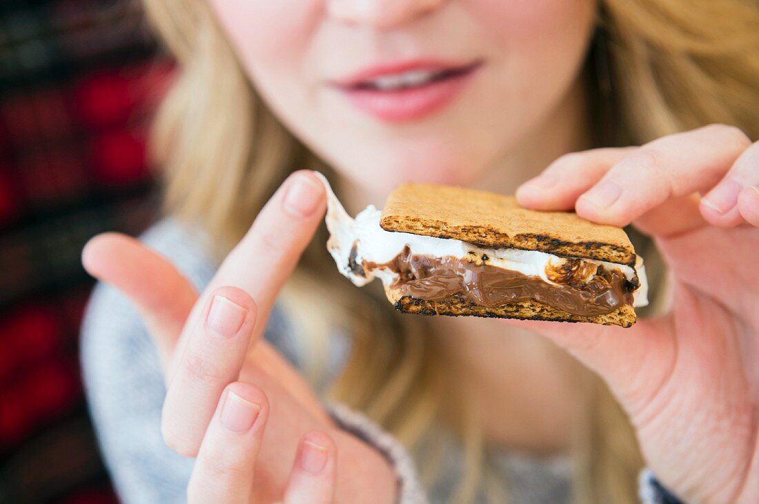 Junge Frau isst Smore