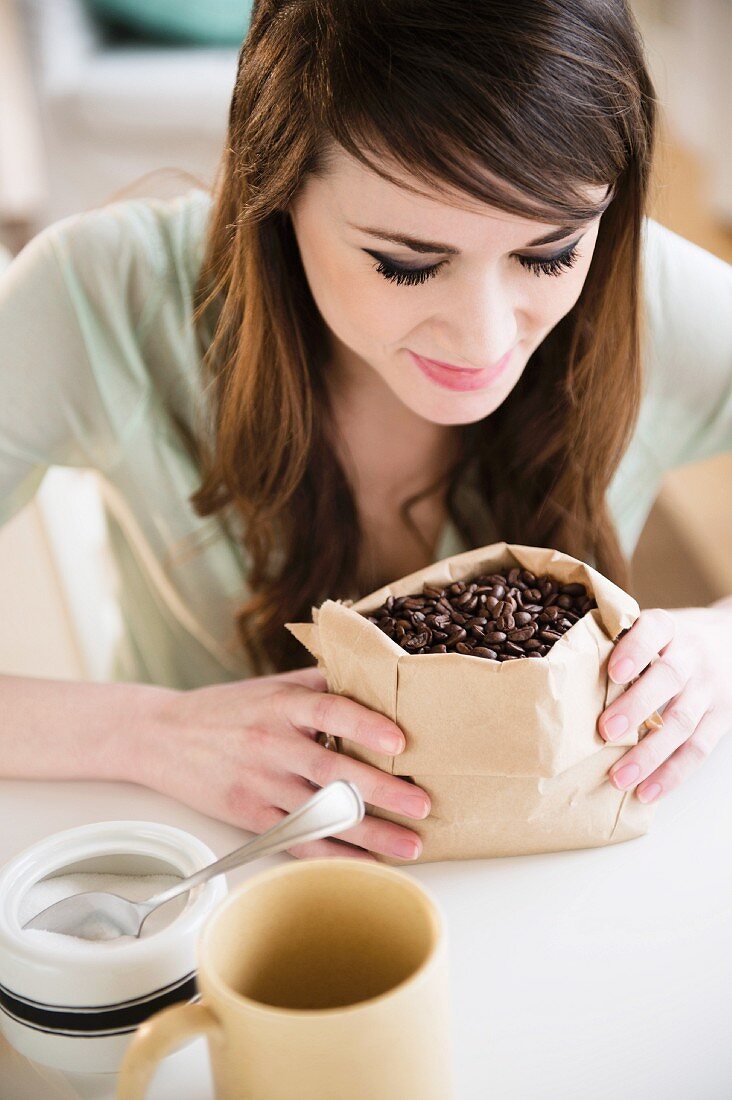 Junge Frau schaut auf einen Sack Kaffeebohnen
