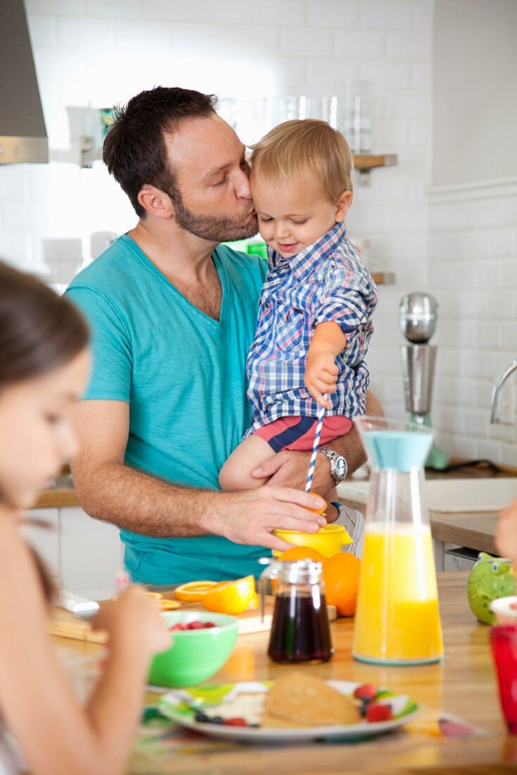 Mann frühstückt mit Sohn und Tochter