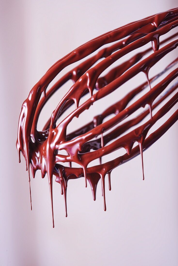 Liquid chocolate dripping from a whisk