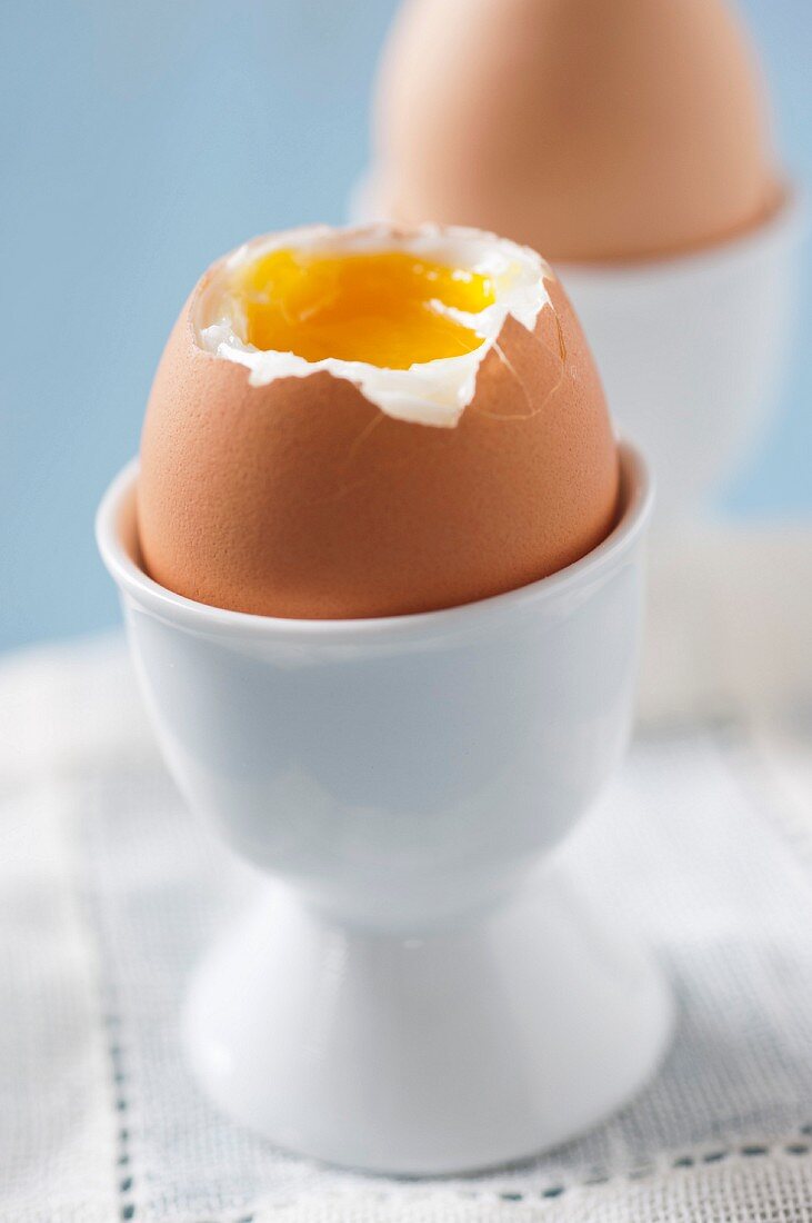 Soft-boiled eggs, one decapitated and one whole