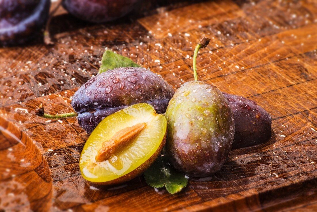 Freshly washed plums on a wooden board