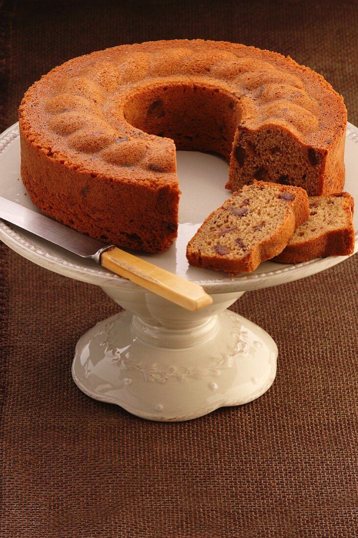 Date and coffee cake, sliced, on a cake stand