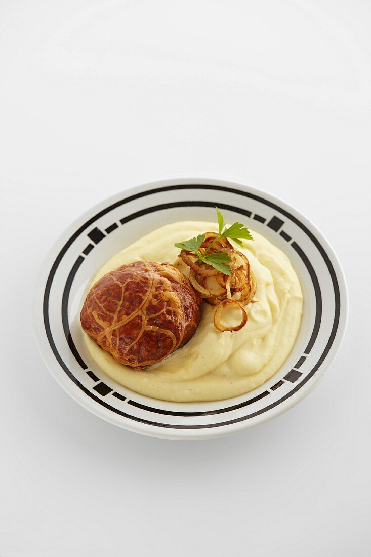 Saumaise (cured pork meat loaf from Austria) with mashed potatoes and onion rings