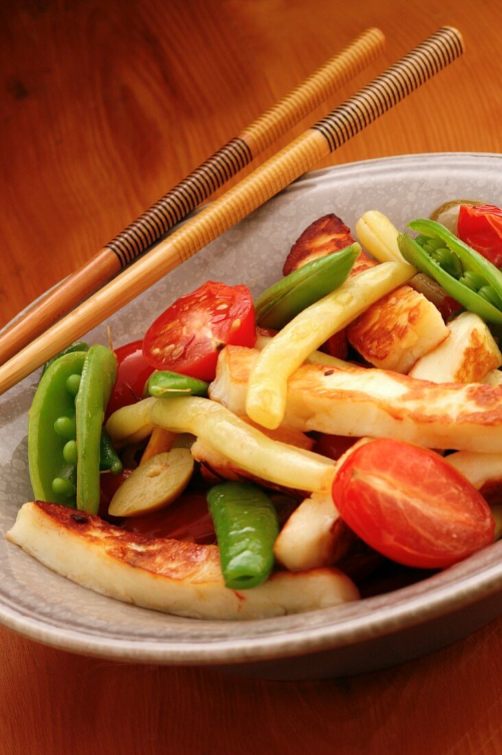 Fried vegetables in a bowl with chopsticks