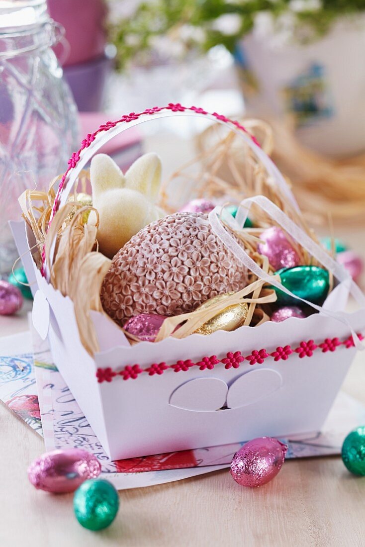 Easter sweets in paper basket decorated with floral ribbonr