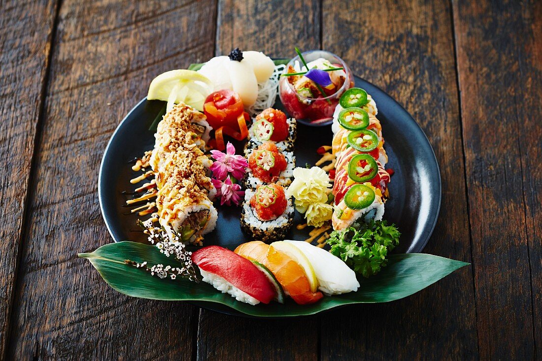 A sushi and sashimi platter on a wooden surface