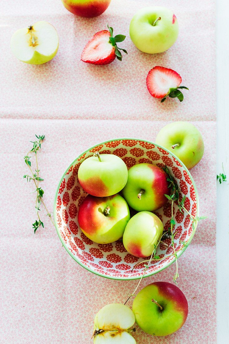 Stillleben mit Äpfeln in einer Schüssel und Erdbeeren