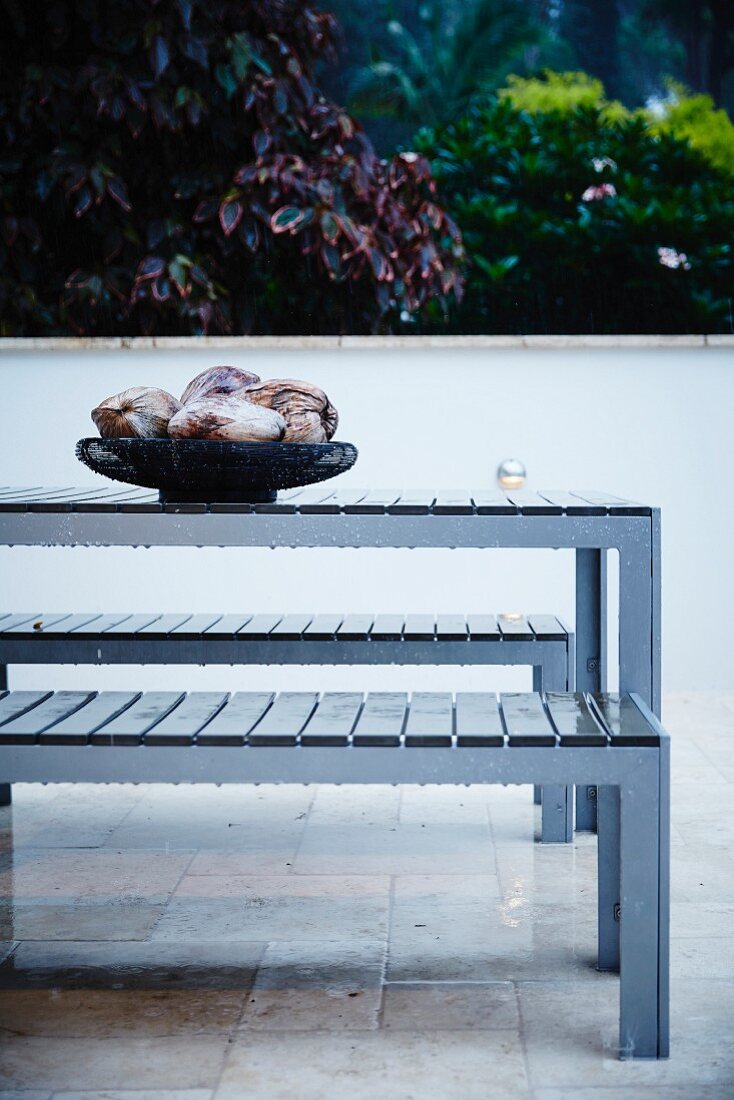 Tisch mit Sitzbänken auf Terrasse mit Fliesenboden